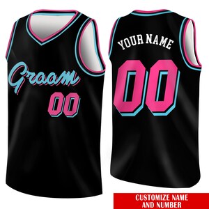 May include: Black basketball jersey with pink and blue accents. The jersey has the text "Groom" and the number "00" on the front. The back of the jersey has the text "YOUR NAME" and the number "00".