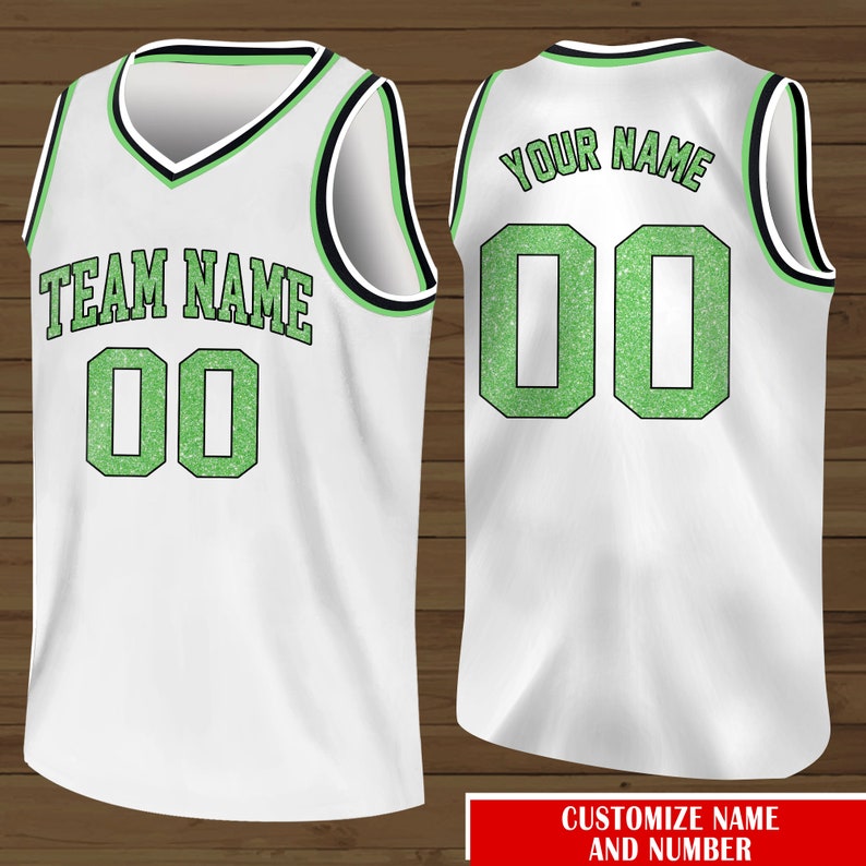 Puede incluir: Camiseta de baloncesto blanca con detalles de purpurina verde. La parte delantera de la camiseta dice "TEAM NAME 00" y la parte trasera dice "YOUR NAME 00".