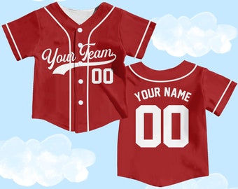 A little boy in a red baseball jersey sitting on a ledge · Free Stock Photo