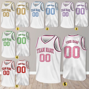 Puede incluir: Seis camisetas de baloncesto blancas con n&uacute;meros y texto de diferentes colores. Las camisetas tienen cuello en V y son sin mangas. Los n&uacute;meros son 00 y el texto dice "TEAM NAME" y "YOUR NAME".