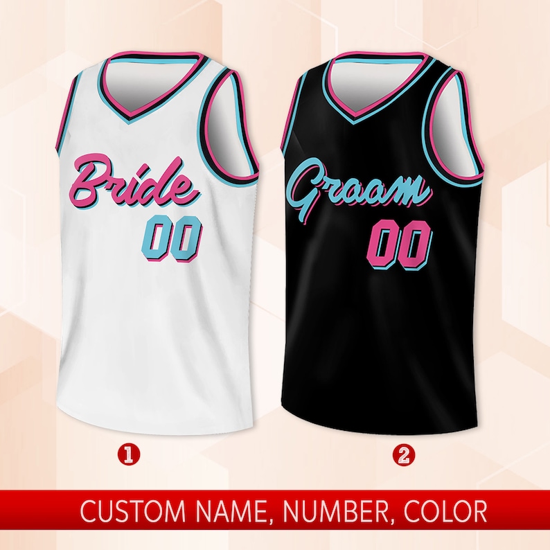 May include: Two basketball jerseys, one white with "Bride 00" in pink and blue lettering, and one black with "Groom 00" in pink and blue lettering.