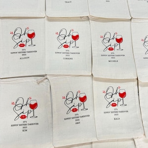 K&ouml;nnte beinhalten: Eine Sammlung von beigefarbenen Stoffbeuteln mit Kordelzug, bedruckt mit einer Grafik eines Weinglases und roten Lippen. Der Text lautet Oh Sip! It's Sippin' Sisters Takeover 2025, erg&auml;nzt durch Namen wie Tracy, Allison, Corrine, Michele, Amy und Kala.