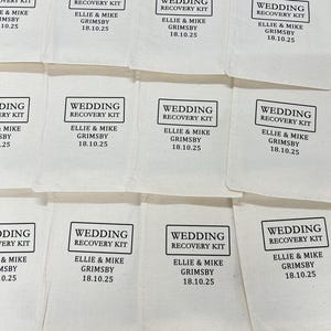 K&ouml;nnte beinhalten: Eine Sammlung von cremefarbenen Baumwollbeuteln mit Kordelzug, die jeweils mit einem schwarzen rechteckigen Rahmen bedruckt sind, der den Text WEDDING RECOVERY KIT sowie die Namen ELLIE & MIKE GRIMSBY und das Datum 18.10.25 enth&auml;lt.