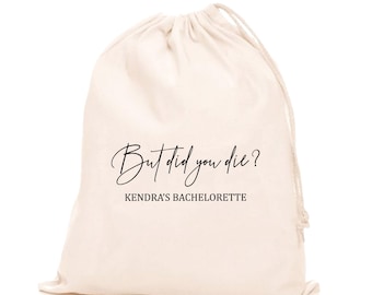 May include: A white cotton drawstring bag with the text "But did you die? Kendra's Bachelorette" printed in black.
