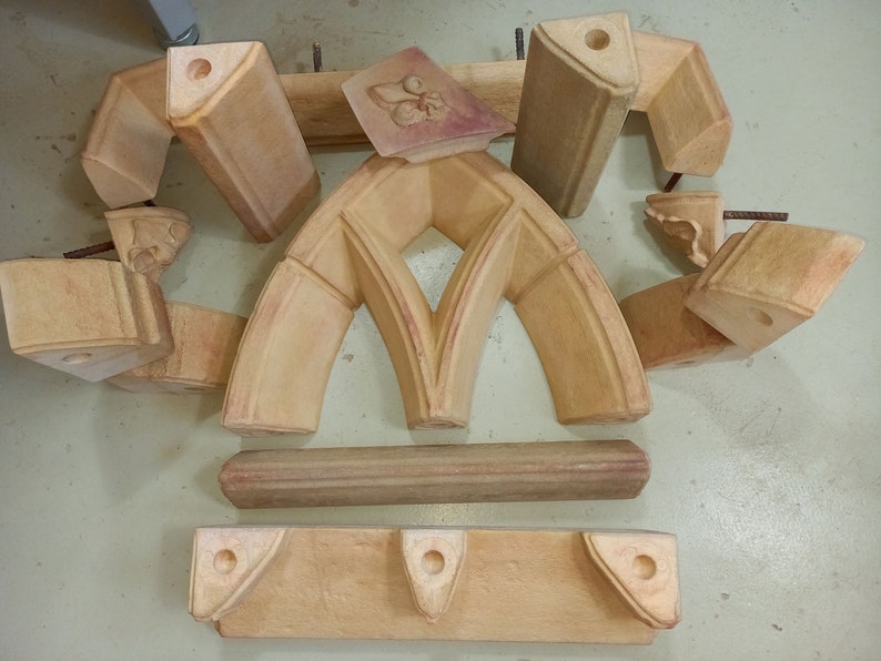May include: A set of 10 wooden molds for creating a decorative archway. The molds are made of light brown wood and have a smooth, polished finish. The molds are arranged in a circle on a light brown surface.