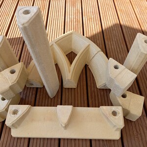 May include: A set of nine beige stone pieces that can be assembled to create a decorative archway. The pieces are made of a lightweight material and have a rough, textured surface.
