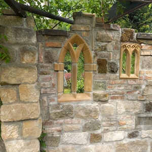 May include: A stone wall with two arched windows. The windows are made of a light brown stone and have a pointed arch. The wall is made of a variety of stones, including brown, gray, and white.