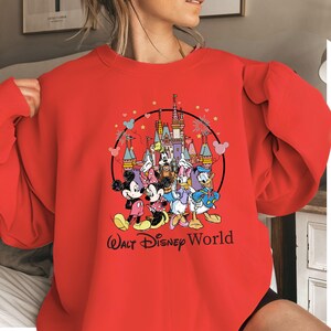 May include: A white ceramic mug with a black handle and the text "But First, Coffee" in a handwritten style. The mug is on a white surface. The mug is approximately 4 inches tall.