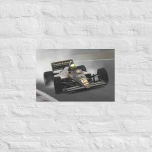 May include: A black and gold Formula 1 race car with the number 12 on the side, driven by a driver wearing a green helmet. The car is on a race track and is surrounded by a blur of motion.