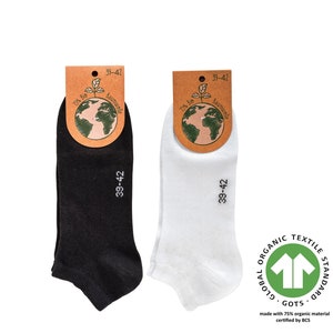 May include: Two pairs of ankle socks, one black and one white, with a tag that says "100% Bio Baumwolle" and "39-42". The socks are made with 75% organic material certified by GOTS.