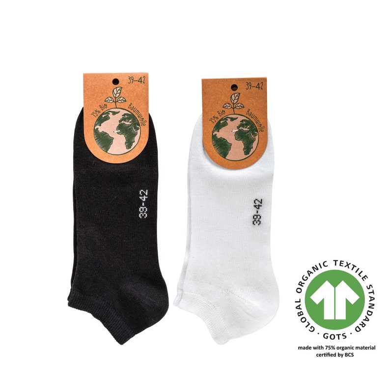 May include: Two pairs of ankle socks, one black and one white, with a tag that says "100% Bio Baumwolle" and "39-42". The socks are made with 75% organic material certified by GOTS.