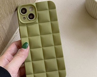 May include: A green quilted phone case for an iPhone with a camera bump.