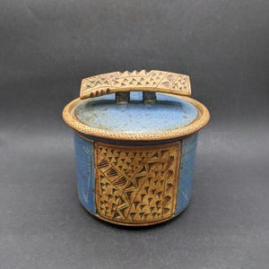 Tarro de cerámica de estudio con tapa y decoración de esgrafiado, recipiente torneado con esmalte azul moteado y tapa escultural, tarro de cerámica vintage.