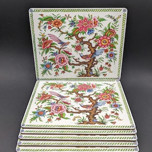 Könnte beinhalten: Set aus sechs quadratischen Untersetzern mit Blumen- und Vogeldesign. Die Untersetzer haben einen weißen Hintergrund mit einer farbenfrohen Illustration eines Baumes mit rosa, roten und orangen Blumen sowie blauen und roten Vögeln. Die Ränder haben einen grünen Rand.