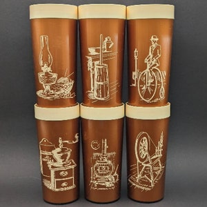 Op de afbeelding: Set van zes bruine plastic bekers met witte illustraties van vintage huishoudelijke artikelen. De illustraties omvatten een lamp, een roomklopper, een fiets, een koffiemolen, een houtkachel en een spinnewiel.