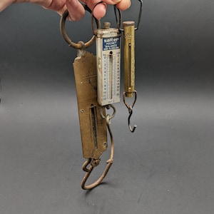 Puede incluir: Balanza de bolsillo vintage Salter con un gancho de latón y una escala graduada marcada en onzas. La balanza está hecha en Inglaterra y tiene un acabado en latón.