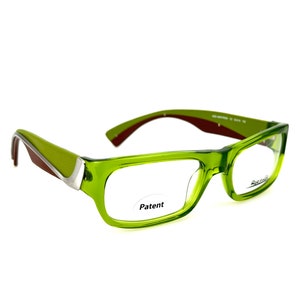 May include: Green and silver eyeglasses with a rectangular frame. The frame has a brown stripe on the side. The word "Patent" is printed on the right lens.