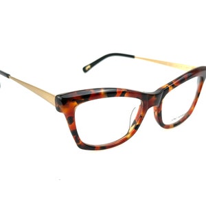 May include: Tortoiseshell cat-eye glasses with gold metal arms.