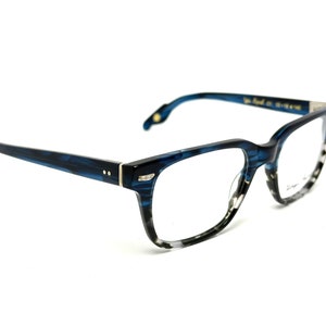 Puede incluir: Gafas de vista de carey azul y transparente con un acento plateado en el puente.