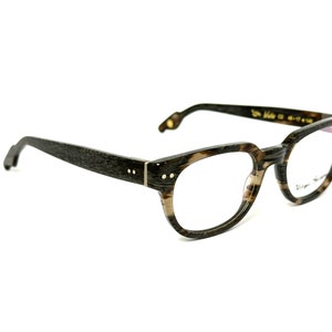 Puede incluir: Gafas de vista de carey marrón y negro con detalles dorados. Las gafas tienen una forma redonda clásica y lentes transparentes.