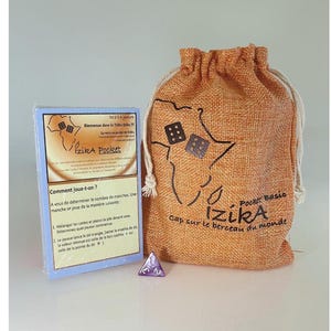 Peut inclure: Un sac en toile de jute brun avec une fermeture à cordon, représentant un contour noir du continent africain et le texte "Pocket Basic Izika cap sur le berceau du monde". Le sac contient un dé à six faces violet avec des chiffres blancs et une carte bleue avec le texte "Izika Pocket" et des instructions pour jouer au jeu.