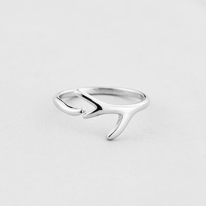 May include: A silver ring with a simple antler design.