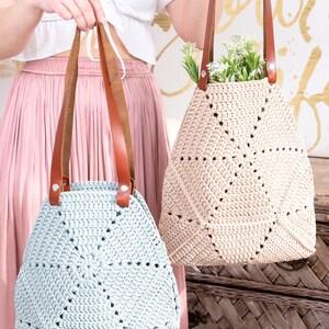 Op de afbeelding: Twee gehaakte tassen met leren handvatten. De tas links is lichtblauw en de tas rechts is beige.