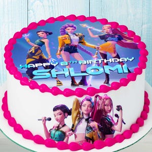 Peut inclure: Un gâteau blanc orné d'une image vibrante de trois personnages féminins animés, avec le texte "HAPPY 8TH BIRTHDAY SHLOMI" en bleu. Le gâteau est bordé d'une bordure de glaçage rose vif.