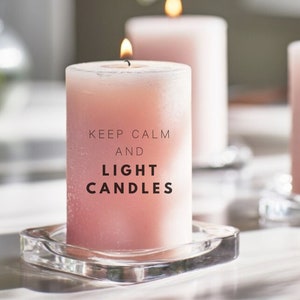 May include: Three pink candles with a glass base. The middle candle has the text "Keep Calm and Light Candles" printed on it.