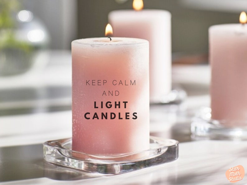 May include: Three pink candles with a glass base. The middle candle has the text "Keep Calm and Light Candles" printed on it.