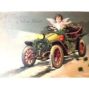 May include: A vintage postcard depicting a cherub driving a yellow car adorned with green shamrocks. The text "A Joyous New Year" is written in the top left corner.