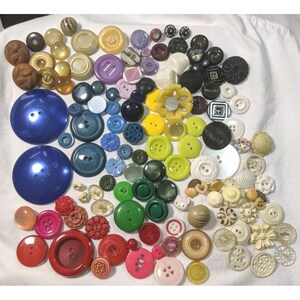 May include: A large collection of vintage buttons in various colors, shapes, and sizes. The buttons are made of plastic, metal, and other materials. Some of the buttons have intricate designs, while others are simple and plain.