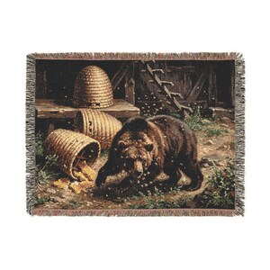 Peut inclure: Un plaid tissé représentant un ours brun foncé entouré d'abeilles près de deux ruches en paille et de rayons de miel renversés. La scène se déroule dans un espace extérieur rustique avec une structure en bois en arrière-plan et des franges.