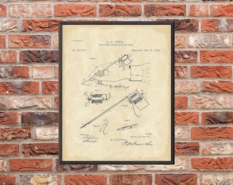 May include: Framed vintage patent print of an electric perforating pen, dated November 8, 1892. The black and white illustration shows the pen's components and a hand using it. The print is in a black frame.