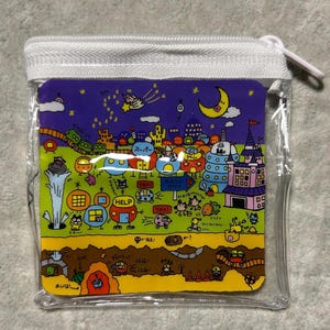 Pu&ograve; includere: Un astuccio quadrato trasparente con cerniera e un'illustrazione a cartoni animati colorata. L'illustrazione presenta un paesaggio urbano stravagante con edifici, veicoli e personaggi sotto un cielo stellato con una luna a mezzaluna. L'astuccio ha una cerniera bianca.