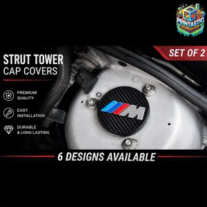 Può includere: Coperture per tappi del montante in fibra di carbonio nera con il logo BMW in blu, rosso e argento. L'immagine include il testo "STRUT TOWER CAP COVERS", "PREMIUM QUALITY", "EASY INSTALLATION", "DURABLE & LONG LASTING", "SET OF 2" e "6 DESIGNS AVAILABLE".
