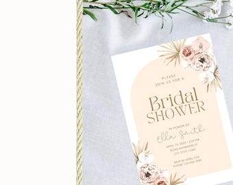 May include: A bridal shower invitation with a floral design in soft peach and beige tones. The invitation includes the text "Bridal Shower" and event details. Decorative elements include dried flowers and palm leaves.