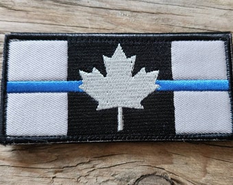 Naszywka z niebieską linią Kanady w jasnoszarym kolorze.