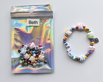 May include: A kit to make a personalized bracelet with colorful beads and letter beads that spell out the name "Beth".