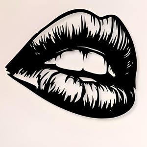 以下が含まれることがあります： スタイリッシュな唇のペアを描いた、白黒の大きな壁掛けアート。白い壁に設置され、手前に木製のキャビネットと椅子があります。唇はシャープな線で詳細に描かれています。