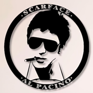 May include: Black and white metal wall art featuring a silhouette of Al Pacino as Tony Montana from the movie Scarface. The art is circular and has the text "Scarface" and "Al Pacino" around the edge.