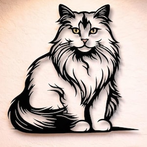 Op de afbeelding: Een zwart-wit metalen kattenkunstwerk voor aan de muur. De kat is afgebeeld in een zittende positie met gedetailleerde vacht en gele ogen. Het kunstwerk is bevestigd aan een lichtgekleurde muur.