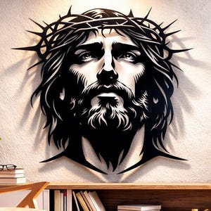 Puede incluir: Una obra de arte mural de metal negro que representa el rostro de Jesús con una corona de espinas. La obra de arte está montada en una pared de color claro sobre una consola de madera. La habitación está decorada con una silla, plantas e iluminación decorativa.