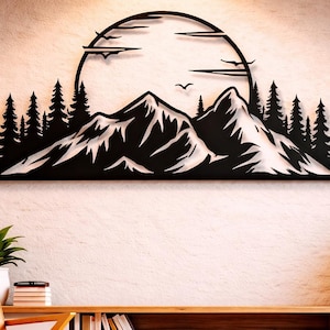 Peut inclure: Décoration murale en métal noir représentant une chaîne de montagnes, des arbres et un soleil. L'œuvre est fixée sur un mur texturé au-dessus d'un meuble en bois et d'une chaise moderne du milieu du siècle. Deux lampes suspendues dorées sont suspendues au plafond.