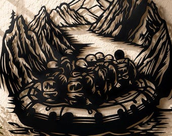 May include: A black metal wall art piece depicting a group of people in a raft navigating a river surrounded by mountains and pine trees. The design features intricate cutouts showing the water, the raft, and the mountainous landscape.