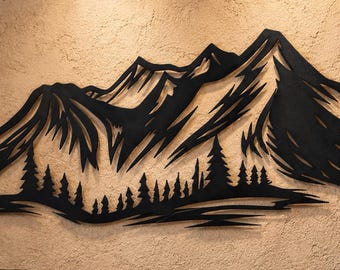 May include: A black metal wall art piece featuring a stylized mountain range silhouette with a dense forest of pine trees at the base. The design consists of sharp, angular lines depicting jagged peaks and a layered forest canopy in a flat finish.