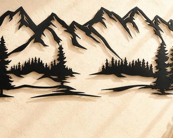 May include: A black metal wall art piece featuring a detailed silhouette of a mountain range with jagged peaks and a dense forest of pine trees at the base. The design is flat and cut out, showcasing a landscape scene with layered evergreen trees.