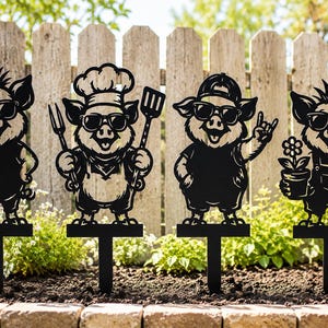 May include: A set of four black metal garden stakes, each featuring a pig character wearing sunglasses. The pigs are depicted with different accessories: one is plain, one holds a spatula and fork, one wears a cap, and one holds a potted flower.