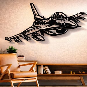 May include: Black metal wall art of a fighter jet, showcasing detailed design elements. The artwork is mounted on a textured, off-white wall, with a modern interior design aesthetic. The jet features intricate cutouts and is a striking decorative piece.