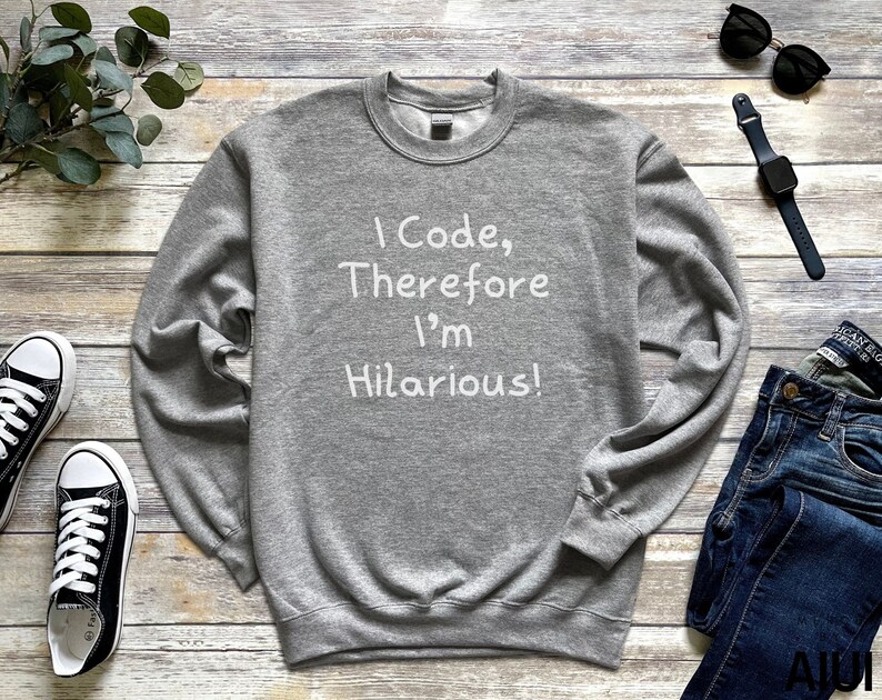 K&ouml;nnte beinhalten: Grauer Pullover mit dem Aufdruck "I Code, Therefore I'm Hilarious!" in Wei&szlig;.